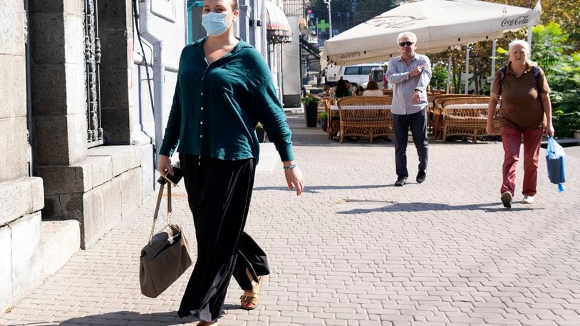 A woman wearing a face mask walks down a street in Kyiv, Ukraine, Friday Sept. 20, 2024 on a day with poor air quality. (AP Photo/Tony Hicks)