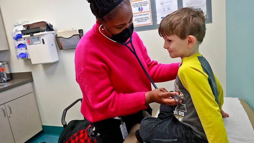 Toyin Adeyanju, a pediatric nurse practitioner, examines Eli Rue, 5, in the pediatric clinic at the Rocking Horse Center Tuesday, Jan. 24, 2023. BILL LACKEY/STAFF