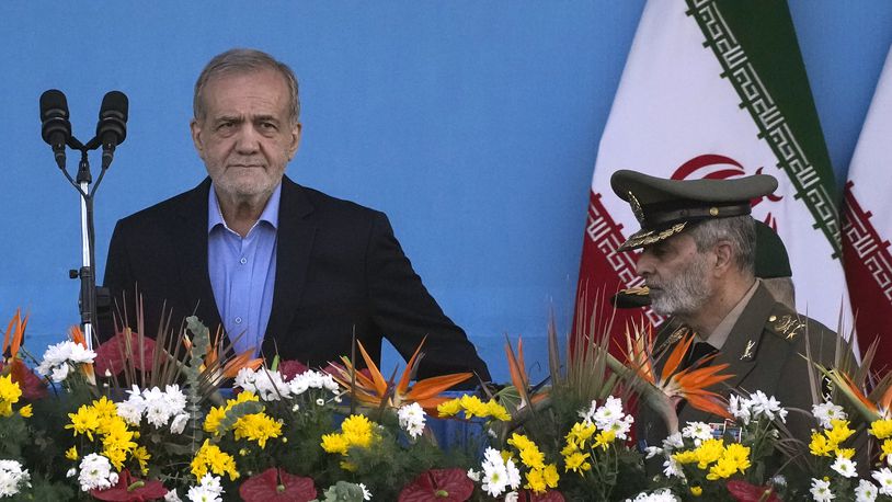 Iranian President Masoud Pezeshkian, left, arrives at the podium, accompanied by the army commander Gen. Abdolrahim Mousavi during an annual armed forces parade marking anniversary of the beginning of war against Iran by former Iraqi Dictator Saddam Hussein 44 years ago, in front of the shrine of the late revolutionary founder Ayatollah Khomeini, just outside Tehran, Iran, Saturday, Sept. 21, 2024. (AP Photo/Vahid Salemi)