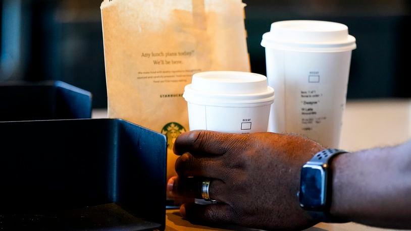 FILE - A customer picks up a drink at a Starbucks on June 28, 2023, in Seattle.(AP Photo/Lindsey Wasson, File)