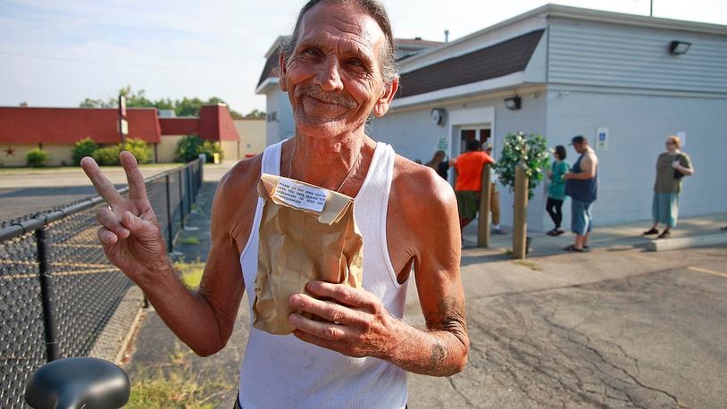 David Blystone, from Springfield, holds up his bag of pot after being the first person in line at The Forest in Springfield Tuesday, Aug. 6, 2024. BILL LACKEY/STAFF