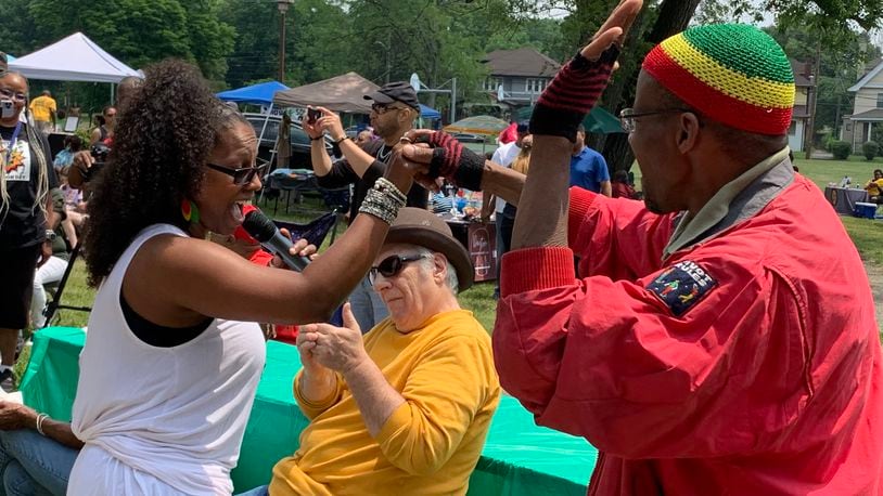 Tiffany Porterfield of the Chazz Band (left) dances with an audience member during the band’s performance at Dayton’s Juneteenth festival. LONDON BISHOP/STAFF