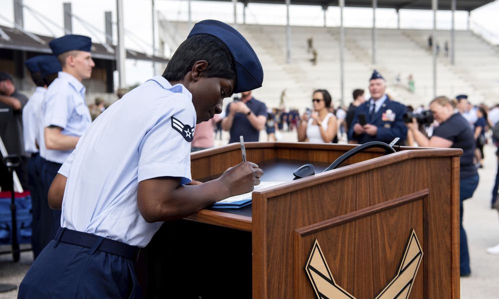 FILE - Airman 1st Class D'elbrah Assamoi, from Cote D'Ivoire, signs her U.S. certificate of citizenship after the Basic Military Training Coin Ceremony at Joint Base San Antonio-Lackland, in San Antonio, April 26, 2023. The Army and Air Force say they are on track to meet their recruiting goals in 2024, reversing previous shortfalls using a swath of new programs and policy changes. But the Navy, while improving, expects once again to fall short. (Vanessa R. Adame/U.S. Air Force via AP, File)