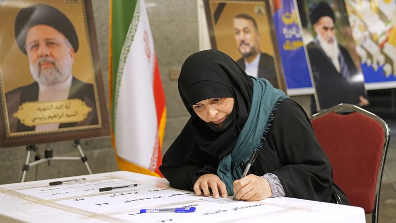 A woman casts her vote during the presidential election at a polling station inside the Iranian embassy in Baghdad, Iraq, Friday, June 28, 2024. (AP Photo/Hadi Mizban)