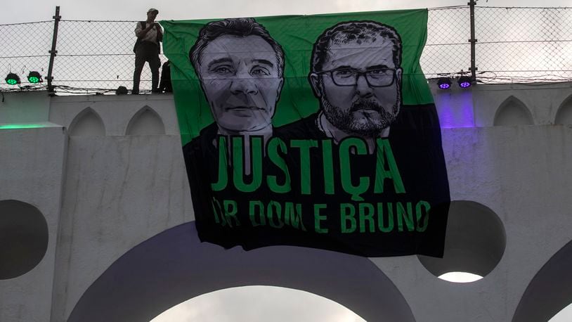 FILE - A sign that reads in Portuguese "Justice for Dom and Bruno" and with images of the British journalist Dom Phillips, on the left, and the indigenous specialist Bruno Pereira is displayed on the Arcos da Lapa aqueduct during a protest by environmental groups in Rio de Janeiro, Brazil, June 26, 2022. (AP Photo/Bruna Prado, File)