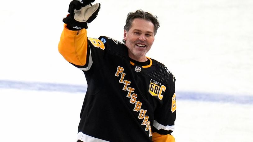 FILE - Former Pittsburgh Penguins player Jaromir Jagr stands at center ice and waves to fans after skating during warm ups after having a banner with his retired uniform number raised to the rafters of PPG Paints arena before an NHL hockey game between the Los Angeles Kings and the Penguins in Pittsburgh, Sunday, Feb. 18, 2024. (AP Photo/Gene Puskar, File)