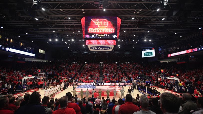 PHOTOS FROM THE BOOK: The Epicenter of College Basketball: A History of UD Arena — Fans stand for the national anthem before a game between Dayton and Indiana State in 2019 at UD Arena. This was the first men’s basketball game since the end of a three-year renovation project that transformed the 50-year old arena. Dayton Daily News photo by David Jablonski