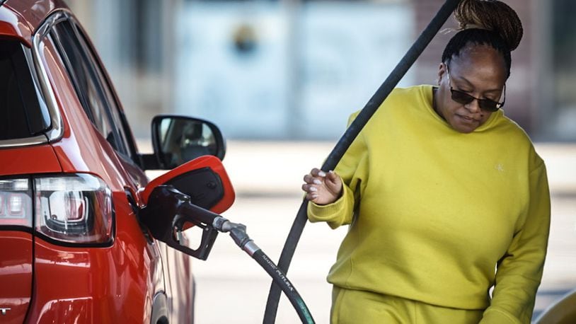 Tamika Duverglas, from Dayton, pumps gas at the UDF at Brown and Stewart Streets Wednesday December 27, 2023. Gas prices have been rising lately because of tensions in the Middle East. JIM NOELKER/STAFF