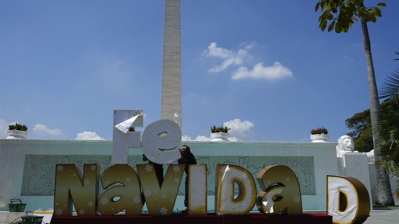 People set up Christmas decorations in Caracas, Venezuela, Tuesday, Oct. 1, 2024. (AP Photo/Ariana Cubillos)