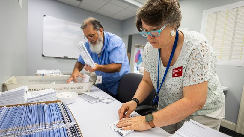 Dawn Stephens, right, and Duane Taylor prepare ballots to be mailed at the Mecklenburg County Board of Elections in Charlotte, N.C., Thursday, Sept. 5, 2024. (AP Photo/Nell Redmond)