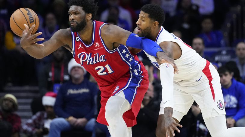FILE - Philadelphia 76ers' Joel Embiid, left, tries to hang onto the ball against Los Angeles Clippers' Paul George during the first half of an NBA basketball game, Friday, Dec. 23, 2022, in Philadelphia. Paul George is going back to the Eastern Conference, and surely has made Joel Embiid very happy in the process. George will sign a four-year, $212 million contract with the Philadelphia 76ers, a person with knowledge of the move told The Associated Press early Monday, July 1, 2024. (AP Photo/Matt Slocum, File)