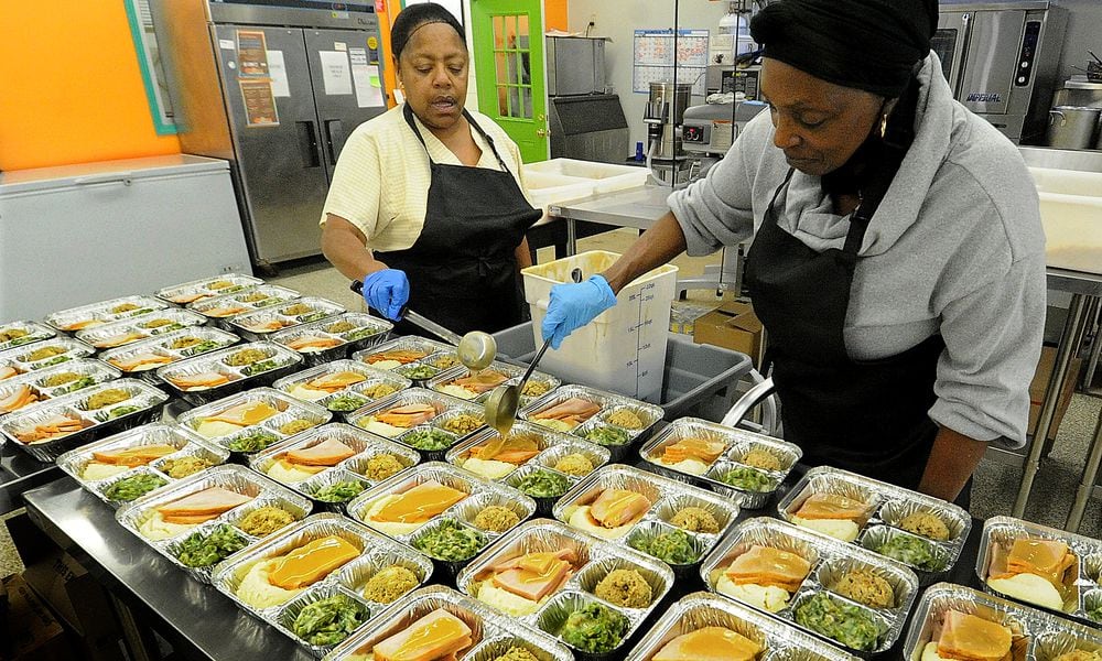 The staff at Miami Valley Meals, Cheryl Robinson, left and Marilyn Britt prepare Thanksgiving meals Monday Nov. 21, 2022. MARSHALL GORBY\STAFF