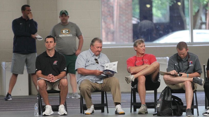 West Virginia coach Bob Huggins, second from left, sits courtside at the Ohio High School Basketball Coaches Association Showcase on Saturday, June 29, 2019, at Capital University in Bexley. David Jablonski/Staff