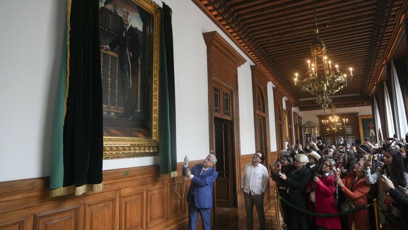 Mexican President Andres Manuel Lopez Obrador unveils his portrait at the National Palace after giving his last morning press conference, "La Mañanera," in Mexico City, Monday, Sept. 30, 2024. (AP Photo/Fernando Llano)