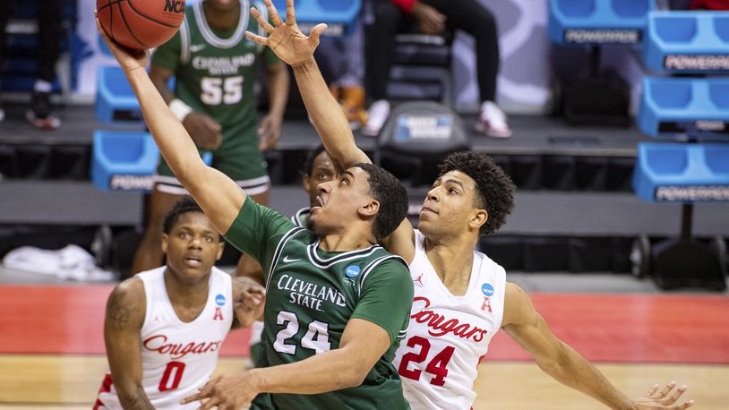 Cleveland State guard Torrey Patton (24), left, slips around the defense of Houston guard Quentin Grimes (24) to score during the first half of a first-round game in the NCAA men's college basketball tournament, Friday, March 19, 2021, at Assembly Hall in Bloomington, Ind. (AP Photo/Doug McSchooler)