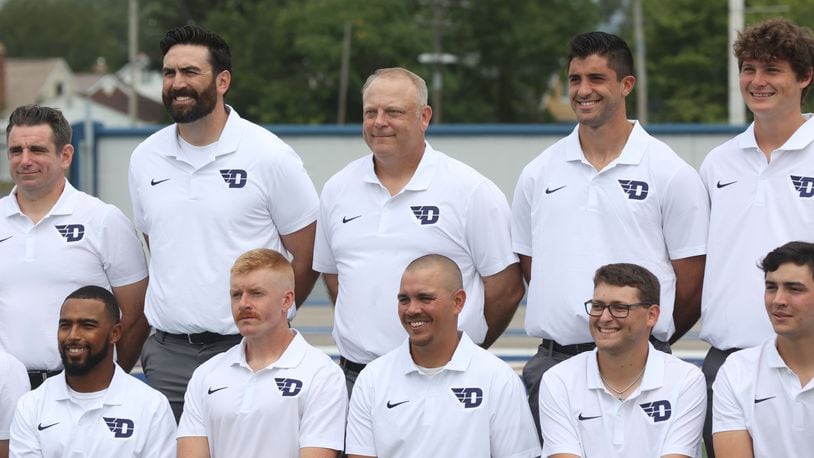 Dayton football coach Trevor Andrews, center, poses for a photo with his staff during the team photo on on media day on Sunday, Aug. 18, 2024, at Welcome Stadium. David Jablonski/Staff