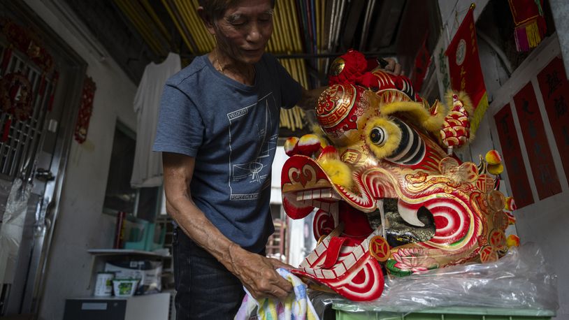 Villager Lo Yuet-ping cleans the head prop that's used in the traditional "Qilin" Dance at the Cha Kwo Ling village in east Kowloon, Hong Kong, Sunday, Aug. 25, 2024. (AP Photo/Chan Long Hei)