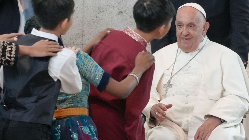 Pope Francis is welcomed by dancing children as he arrives at Singapore Changi International Airport, Wednesday, Sept. 11, 2024. Pope Francis is heading to Singapore for the final leg of his 11-day trip to Asia and Oceania. (AP Photo/Gregorio Borgia)