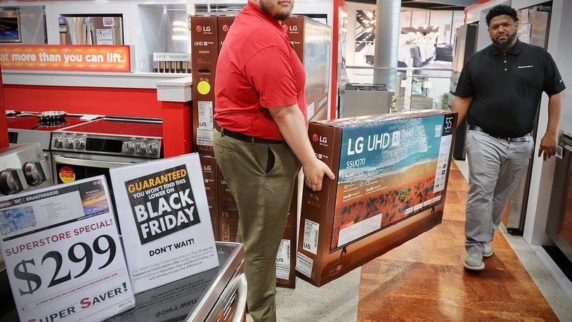Huber Heights Big Sandy Superstore employees, Chad Stapp, left, and Steven Finch, move a 55 inch TV, Wednesday, Nov. 22, 2023 that is on sale Black Friday for $299. MARSHALL GORBY\STAFF