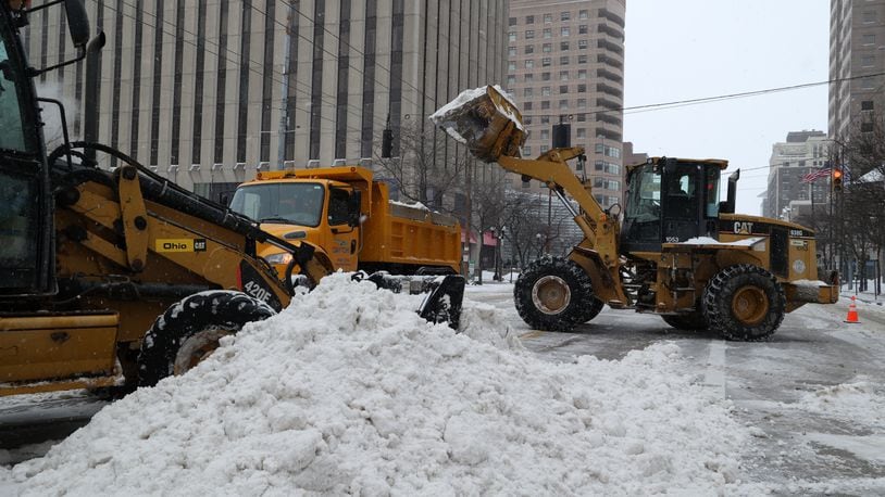Main Street in downtown Dayton was blocked down to one lane in each direction as city crews used heavy equipment to load the snow into trucks Friday morning, Feb. 4, 2022. BILL LACKEY/STAFF