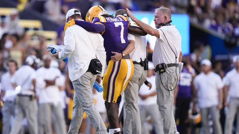 LSU head coach Brian Kelly, right, pats linebacker Harold Perkins Jr. (7) as he is helped off the field after being injured in the second half of an NCAA college football game against UCLA in Baton Rouge, La., Saturday, Sept. 21, 2024. LSU won 34-17. (AP Photo/Gerald Herbert)