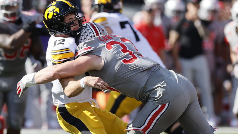 Ohio State defensive lineman Jack Sawyer, right, hits Iowa quarterback Cade McNamara after he throws a pass during the first half of an NCAA college football game, Saturday, Oct. 5, 2024, in Columbus, Ohio. (AP Photo/Jay LaPrete)