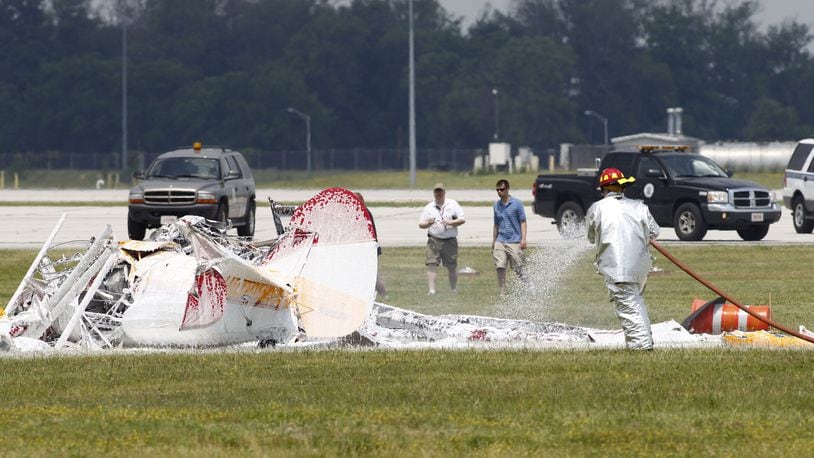 Since 1990, there have been 160 crashes at air shows across America. Not a single year during that time was there not a crash. Wingwalker Jane Wicker, 46, and pilot Charlie Schwenker, 64, crashed and were killed at the Vectren Dayton Air Show on Saturday, June 22. The biplane appears to have crashed just inside the 500-foot show line which is marked by orange construction barrels seen at right. TY GREENLEES / STAFF