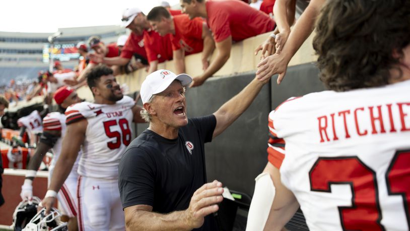 Utah head coach Kyle Whittingham celebrates with players and fans after an NCAA college football game against Oklahoma State, Saturday, Sept. 21, 2024, in Stillwater, Okla. (AP Photo/Mitch Alcala)