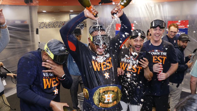 Houston Astros starting pitcher Framber Valdez, center, pours champagne on himself as the team celebrates in the clubhouse after defeating the Seattle Mariners 4-3 to clinch the AL West title after a baseball game Tuesday, Sept. 24, 2024, in Houston. (AP Photo/Michael Wyke)