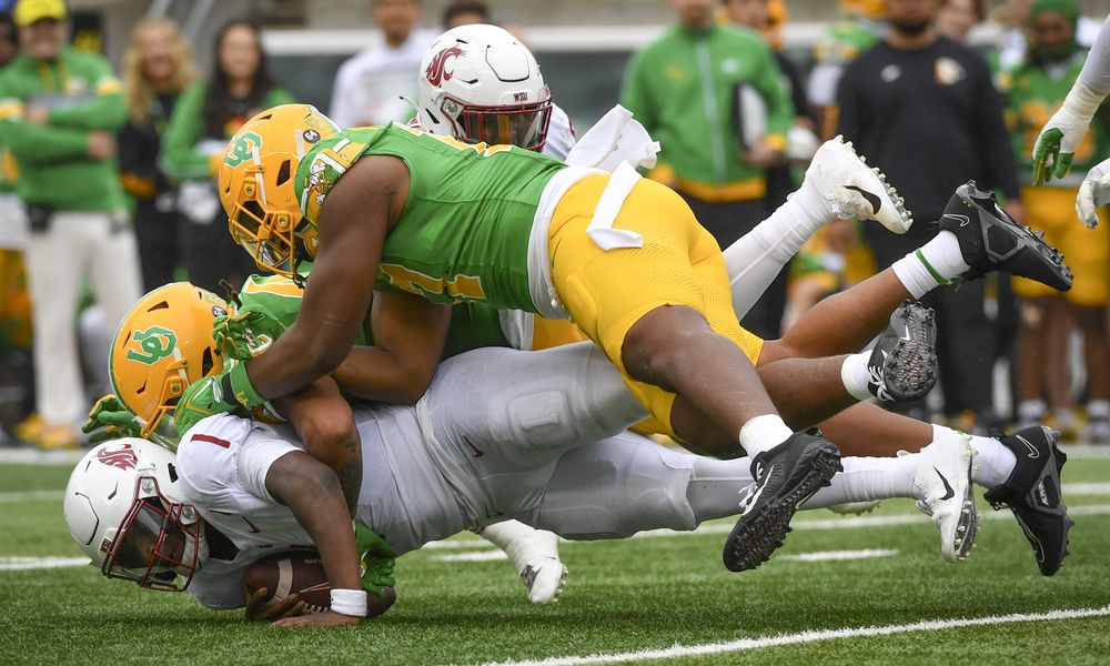 Washington State quarterback Cameron Ward (1) is sacked by Oregon linebackers Jestin Jacobs, center, and Blake Purchase, top, during the second half of an NCAA college football game Saturday, Oct. 21, 2023, in Eugene, Ore. (AP Photo/Andy Nelson)