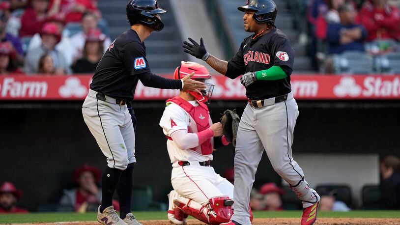 Cleveland Guardians' Jose Ramirez, right, is congratulated by Andres Gimenez after hitting a two-run home run as Los Angeles Angels catcher Logan O'Hoppe kneels at the plate during the third inning of a baseball game Friday, May 24, 2024, in Anaheim, Calif. (AP Photo/Mark J. Terrill)