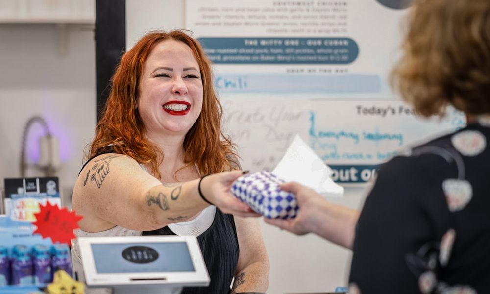 Rachel Gannon, owner of The Local 937 on Fifth Street in the St. Anne's Hill district, delivers a sandwich to a customer Wednesday September 25, 2024. JIM NOELKER/STAFF