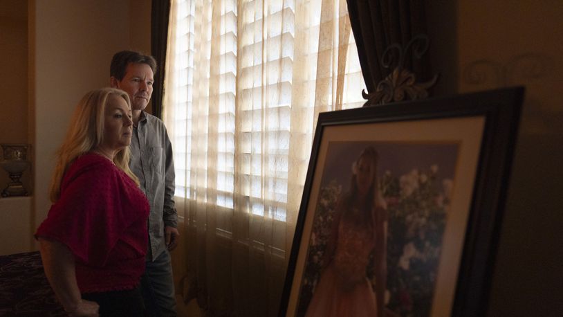 Matt Capelouto and his wife, Christine, whose daughter, Alexandra, died from a fentanyl overdose, stand for a photo next to Alexandra's prom picture in Temecula, Calif., Tuesday, Sept. 17, 2024. (AP Photo/Jae C. Hong)