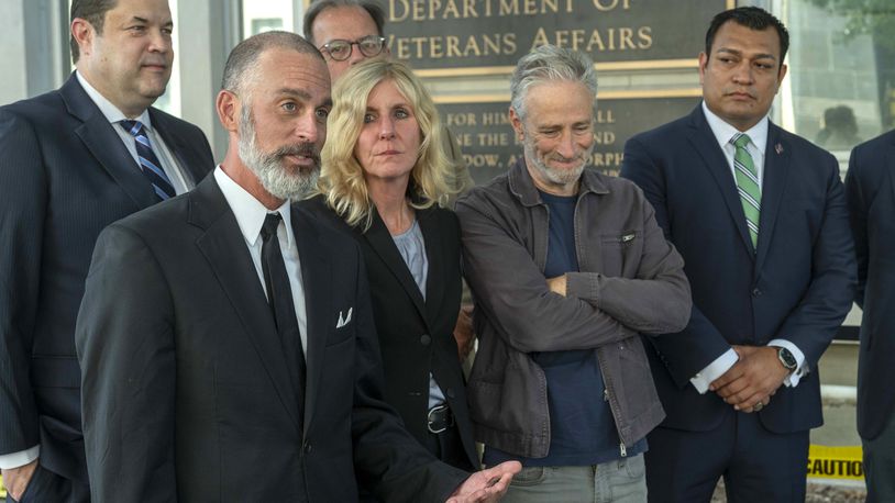 Veteran Mark T. Jackson, second from left, speaks during an interview outside the Department of Veterans Affairs on Friday, July 26, 2024, in Washington. Taking part in the interview with Jackson are from left, Matthew Erpelding, Jackson, Bob Carey, Kim Brooks, Jon Stewart and Chris Villatoro. (AP Photo/Kevin Wolf)