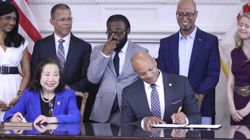 Maryland Gov. Wes Moore signs an executive order to issue more than 175,000 pardons for marijuana convictions on Monday, June 17, 2024 in Annapolis, Md. Maryland Secretary of State Susan Lee is seated left. Standing left to right are Lt. Gov. Aruna Miller, Maryland Attorney General Anthony Brown, Shiloh Jordan, Jason Ortiz, director of strategic initiatives for Last Prisoner Project and Heather Warnken, executive director of the University of Baltimore School of Law Center for Criminal Justice. (AP Phopto/Brian Witte)