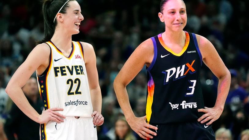 Indiana Fever guard Caitlin Clark (22) and Phoenix Mercury guard Diana Taurasi (3) laugh during the first half of a WNBA basketball game Sunday, June 30, 2024, in Phoenix. (AP Photo/Ross D. Franklin)