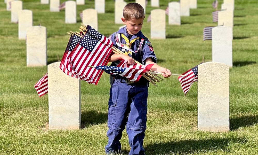 Boy and Girl Scout troops posted American flags at each grave within the Dayton National Cemetery located at the Veterans Medical Center on Saturday. AIMEE HANCOCK/STAFF