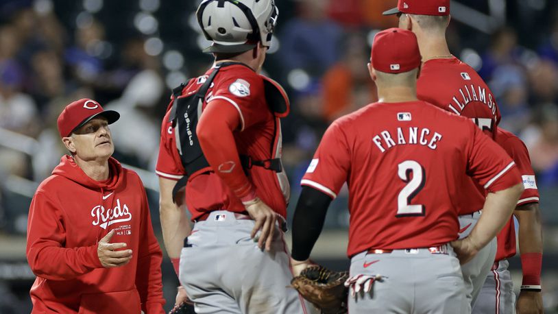 Cincinnati Reds manager David Bell reaches for the ball from pitcher Brandon Williamson during a pitching change in the sixth inning of a baseball game against the New York Mets, Friday, Sept. 6, 2024, in New York. (AP Photo/Adam Hunger)