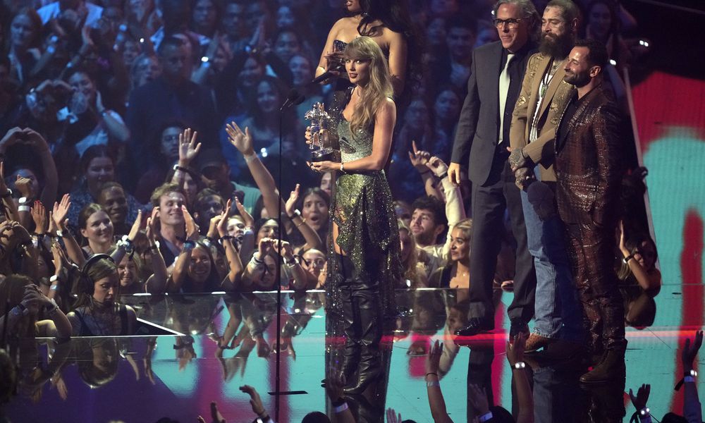 Taylor Swift, center, and Post Malone, third from back left, accept the video of the year award for 