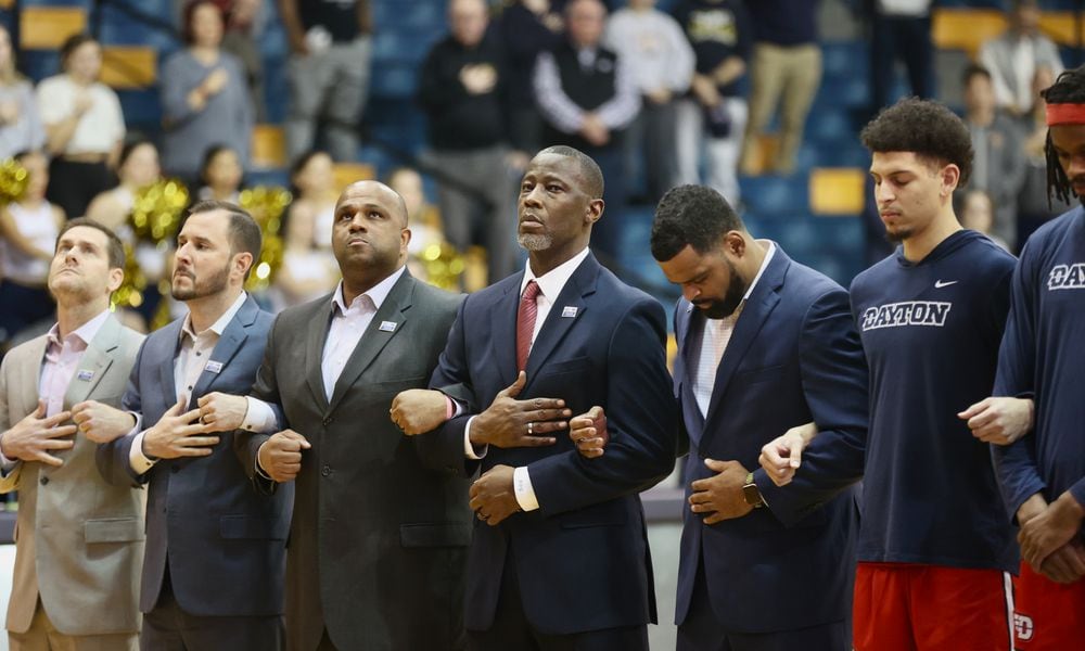 Dayton coach Anthony Grant, center, stands for the national anthem before a game against La Salle on Tuesday, Jan. 23, 2024, at Tom Gola Arena in Philadelphia. David Jablonski/Staff