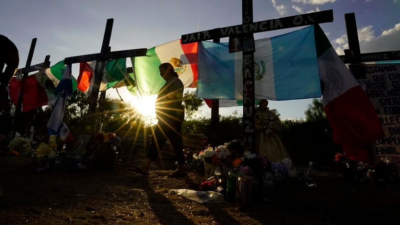 FILE - Mourners visit a make-shift memorial to honor the victims and survivors of the recent human smuggling tragedy, Wednesday, July 6, 2022, in San Antonio. (AP Photo/Eric Gay, File)