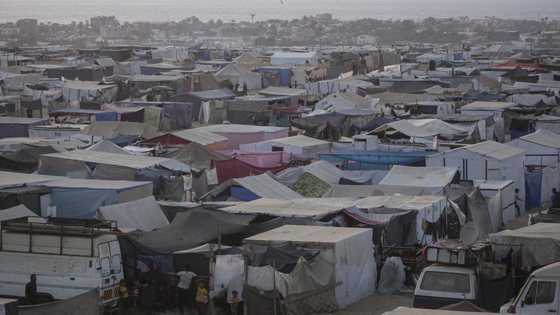 Palestinians displaced by the Israeli air and ground offensive on the Gaza Strip walk through a makeshift tent camp in Khan Younis, Gaza, Tuesday, June 18, 2024. (AP Photo/Jehad Alshrafi)