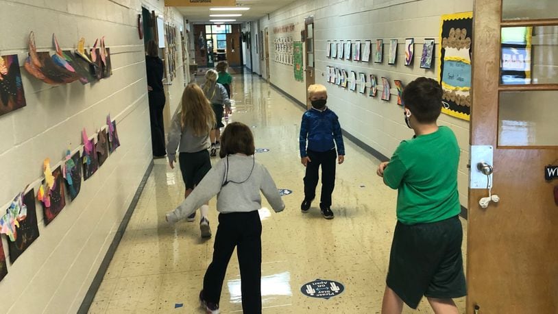 Students at St. Brigid's Catholic School in Xenia keep their distance while walking down the hall for a bathroom break Friday, Sept. 25, 2020.