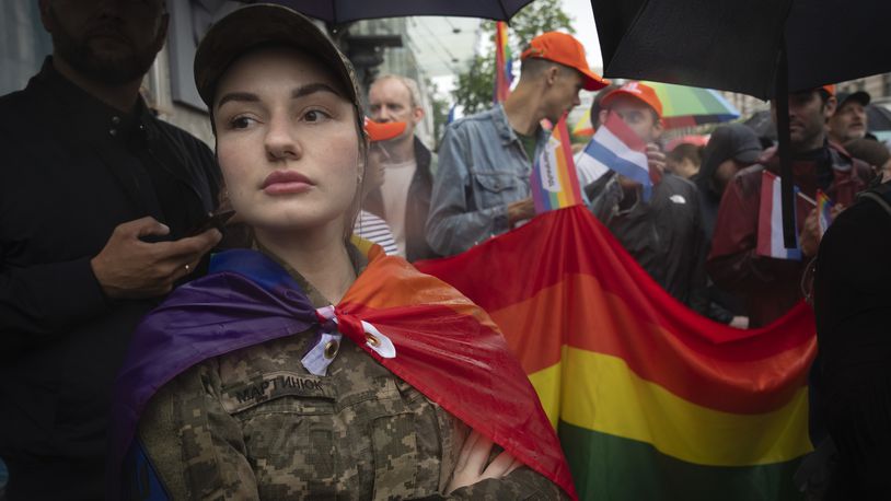 A woman soldier wrapped in the LGBT flag attends a Pride march in Kyiv, Ukraine, Sunday, June 16, 2024. Several hundred LGBT Ukrainian servicemen and other protesters joined the pride march in central Kyiv Sunday seeking legal reforms to allow people in same-sex partnerships to take medical decisions for wounded soldiers and bury victims of the war with Russia that extended across Ukraine more than two years ago. (AP Photo/Efrem Lukatsky)