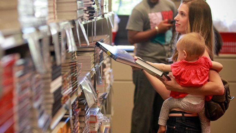Second year Environmental Engineering student Melissa Lacaze shops for text books with her daughter Scarlett in the Sinclair College bookstore Wednesday. Ohio Democrats propose a “pay forward, pay back” system that would replace tuition for state schools. Students would pay a percent of their income after graduation for a certain number of years. This idea is already moving in Oregon and Washington. JIM WITMER / STAFF