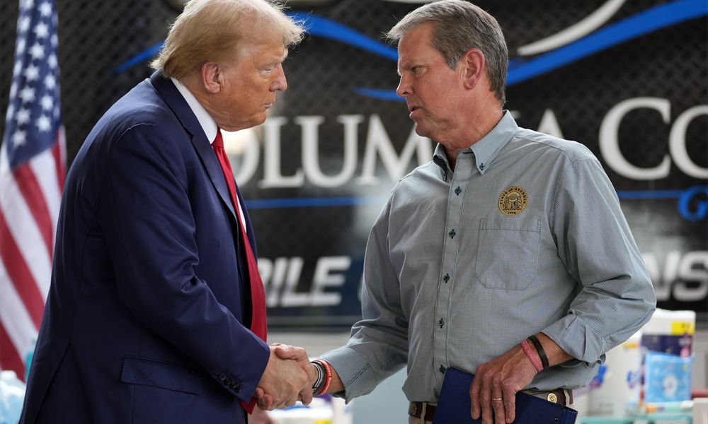 Republican presidential nominee former President Donald Trump shakes hands with Georgia Gov. Brian Kemp after speaking at a temporary relief shelter as he visits areas impacted by Hurricane Helene, Friday, Oct. 4, 2024, in Evans, Ga. (AP Photo/Evan Vucci)