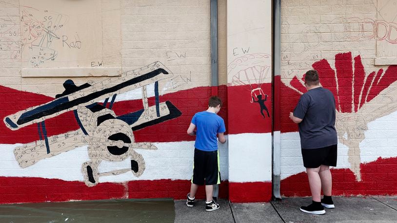 A mural going up along TNT Midwest Martial Arts Academy in Fairborn is not only a tribute to the city's military aviation history, but a positive outlet for kids involved in Greene County Juvenile Courts. MARSHALL GORBY\STAFF