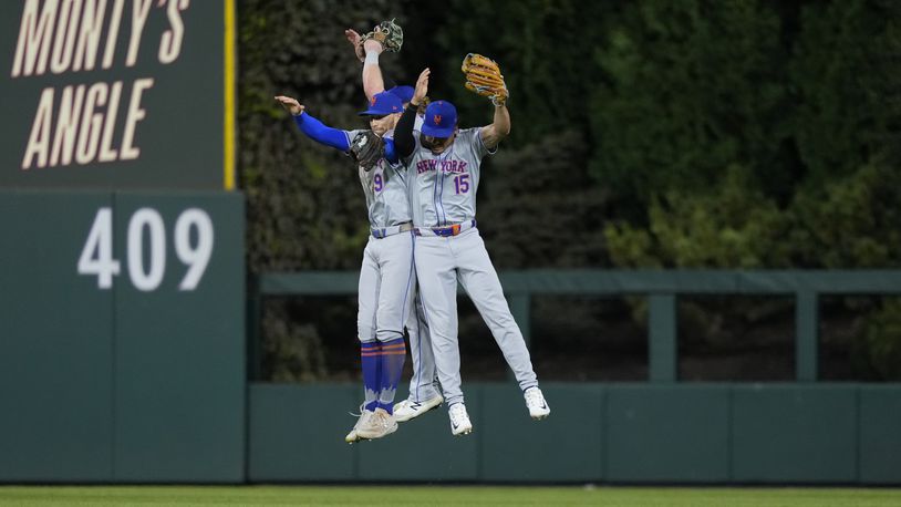 New York Mets' Brandon Nimmo (9) and Tyrone Taylor (15) celebrate after winning Game 1 of a baseball NL Division Series against the Philadelphia Phillies, Saturday, Oct. 5, 2024, in Philadelphia. (AP Photo/Matt Slocum)