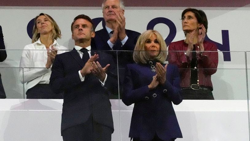 FILE - French Prime Minister Michel Barnier, background center, French President Emmanuel Macron, foreground left, and Macron's wife, Brigitte Macron, foreground right, applaud during the closing ceremony of the 2024 Paralympics, Sunday, Sept. 8, 2024, in Paris, France. (AP Photo/Michel Euler, File)