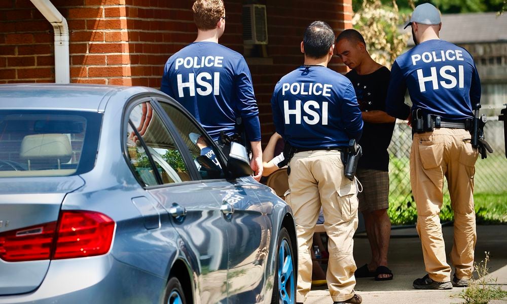 Homeland Security police talk to several people outside a home Friday, July 26, 2024 on Hoyle Pl. in Kettering. MARSHALL GORBY \STAFF